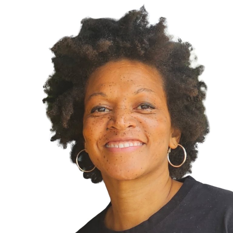 Dionna smiling, wearing gold hoops and a black shirt